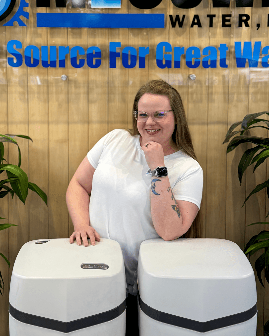 Mandy, office manager at McCowin Water, in front of water treatment equipment
